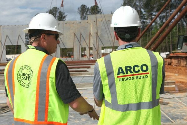 ARCO Design/Build construction photo - workers wearing safety vests and hard hats.