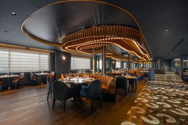 Restaurant dining room with a sculptural illuminated ceiling feature above leather banquettes