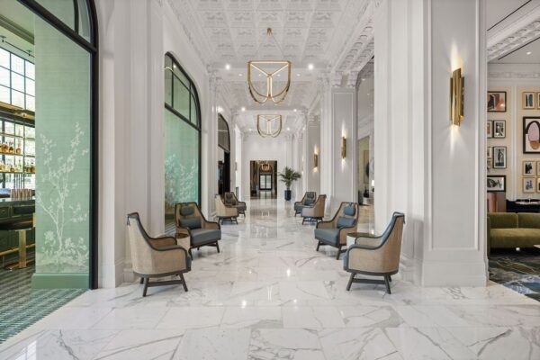 Hotel lobby lounge with marble floors, pressed-plaster ceiling and paired lounge chairs
